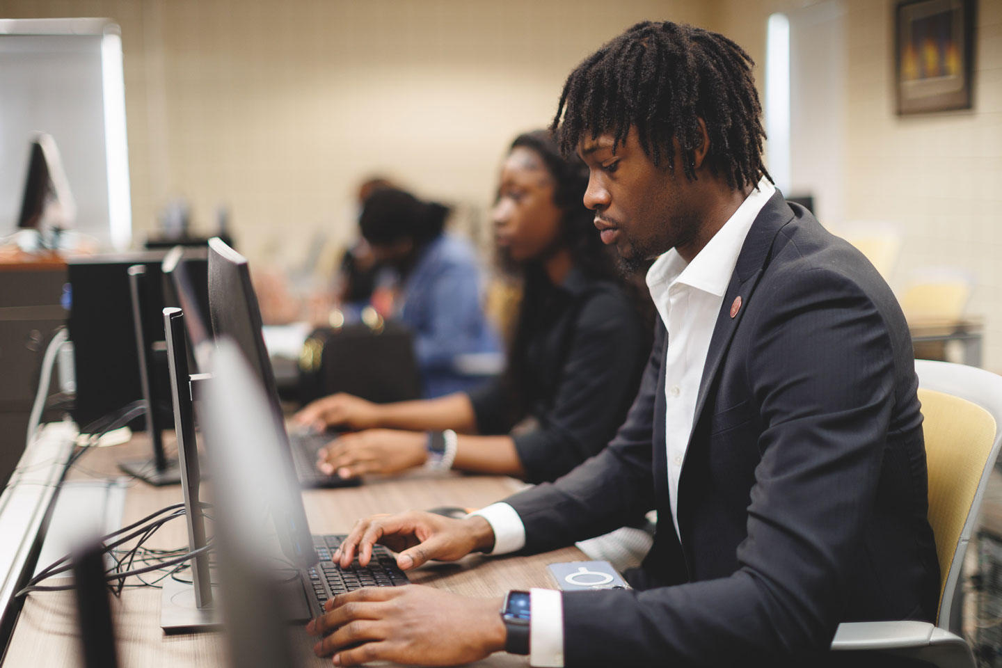 A young student working on a desktop computer in class.