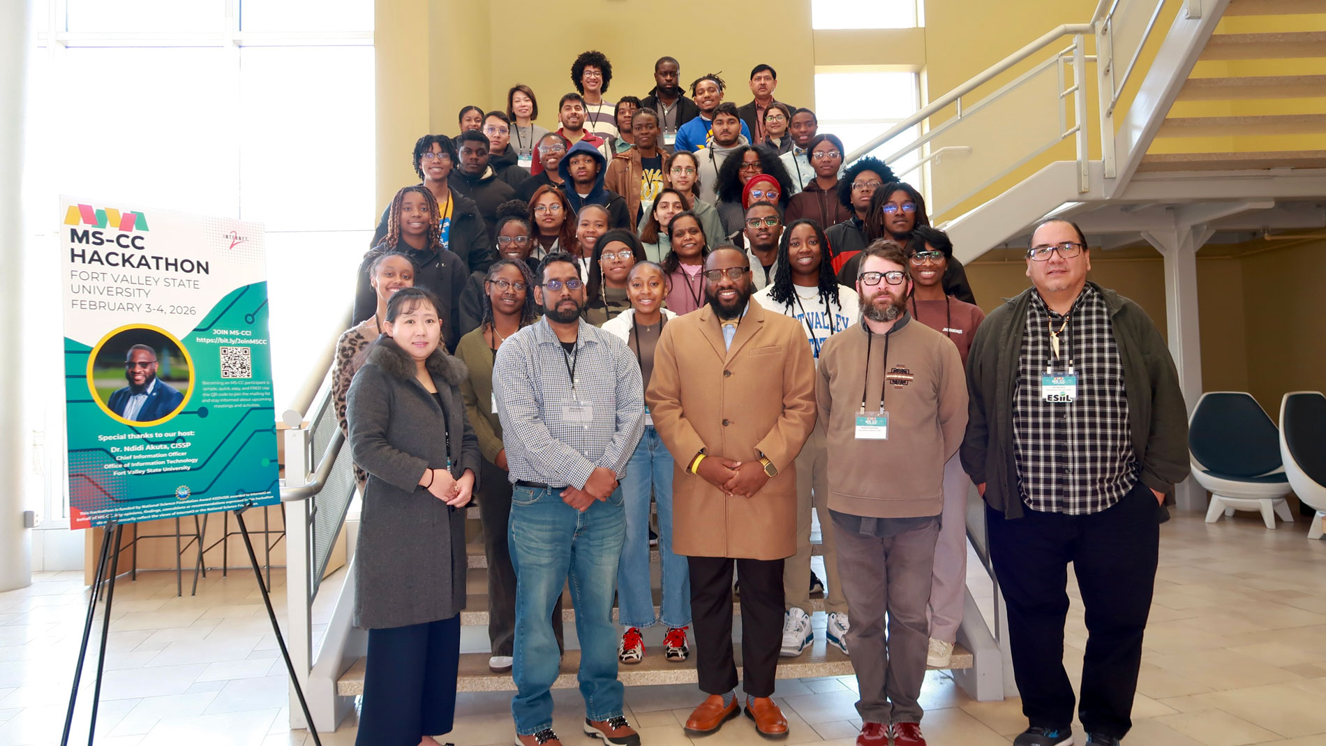 A large group of students and professionals pose for a commemorative photo on and in front of a wide staircase during the MS-CC Hackathon at Fort Valley State University.